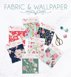 An assortment of colorful fabric and wallpaper samples with whimsical floral designs, displayed with a pair of scissors and thread spools, overlaid by the text "fabric & wallpaper.