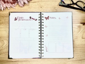 Open notebook titled "Daily Affirmations" on the left page and "Notes" on the right page. The left page has sections labeled "I am", "I will", and "I am grateful for", along with butterfly decorations. The right page has lines for writing and more butterfly decorations.